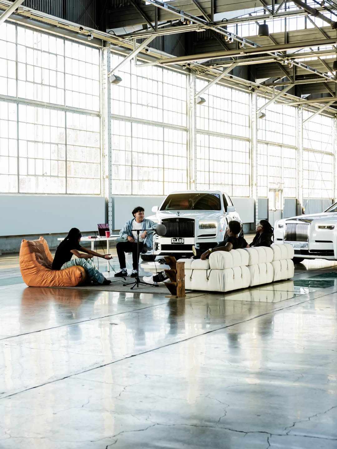 People gathered with cars inside a warehouse
