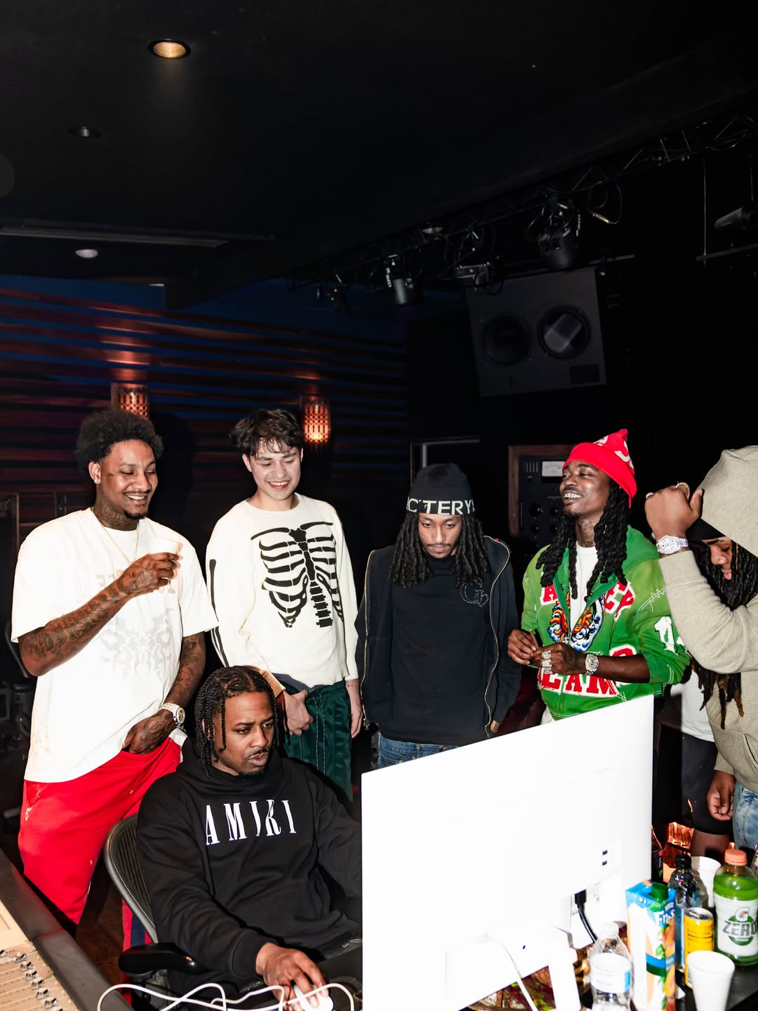 Artists gathered around the computer during a studio session